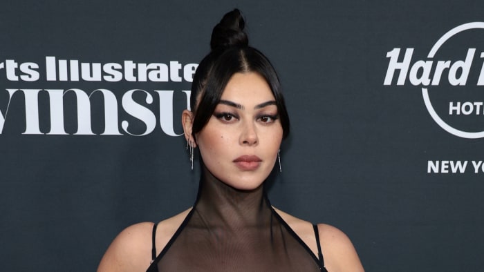 Lauren Chan poses wearing a high neck black dress and her black hair in a bun.